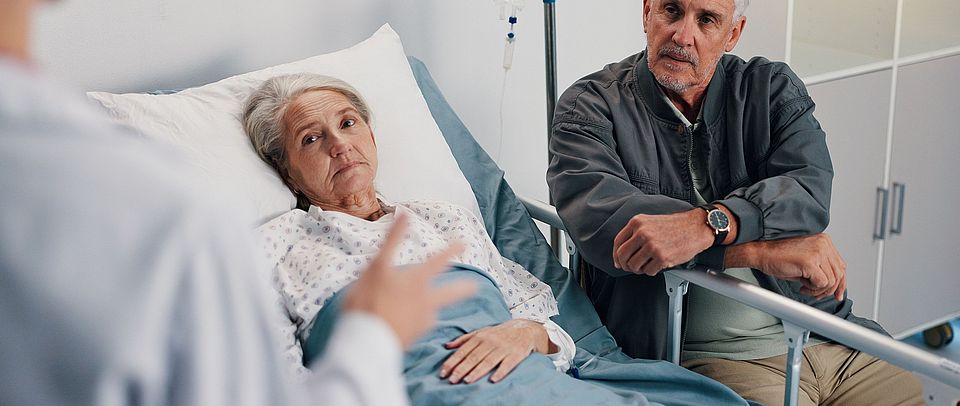 Healthcare, doctor and old couple in hospital, conversation and advice for cancer treatment. Diagnosis, medical emergency and senior woman with elderly man, recovery and consultation with illness NoDoubt-Studie